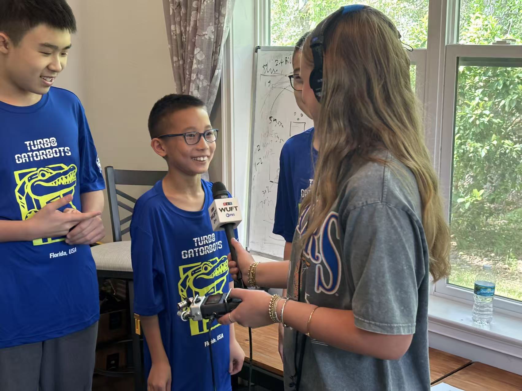 A younger Turbo Gatorbots team member smiling while answering a reporter's questions
