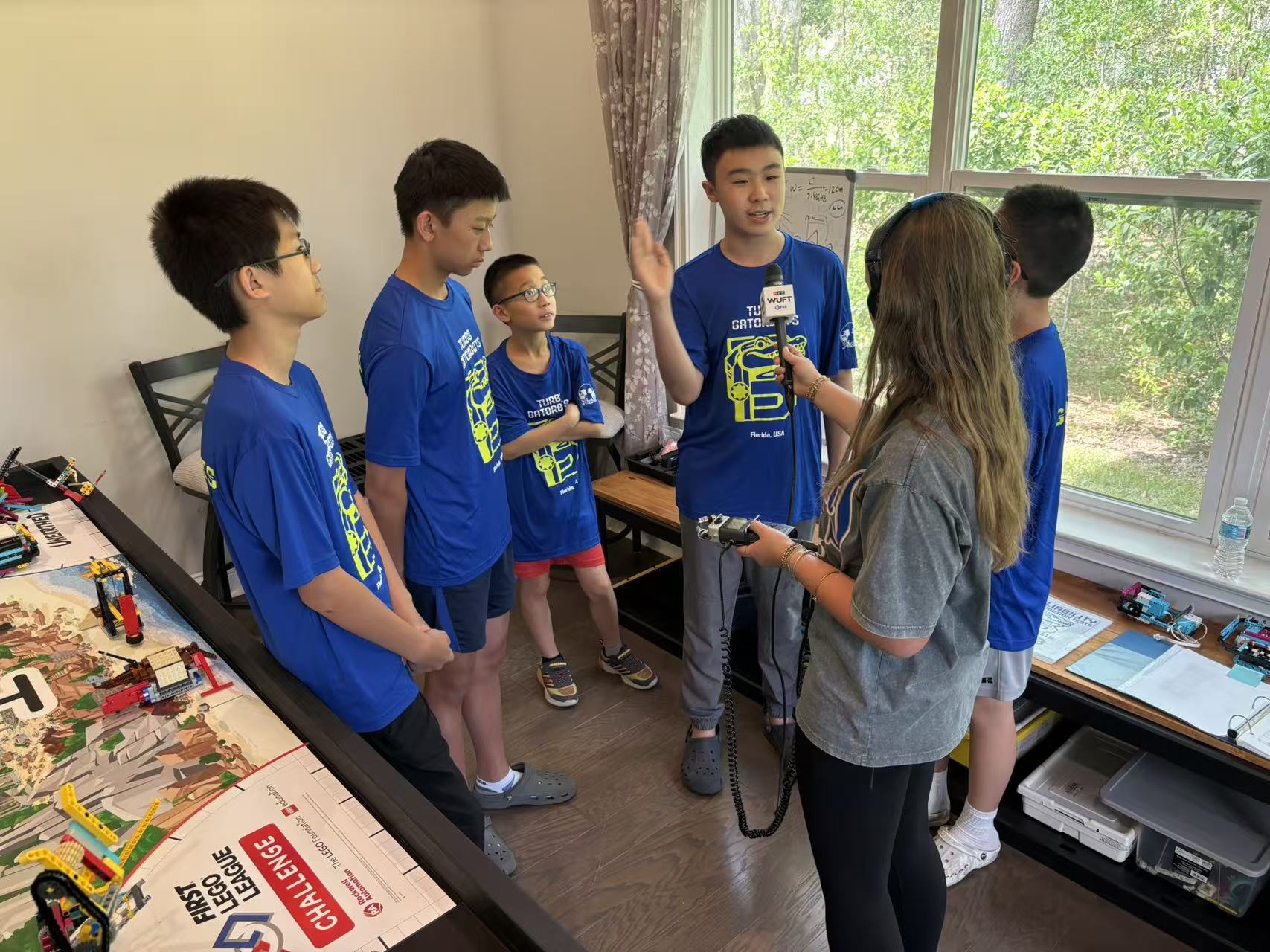 The full Turbo Gatorbots team gathered beside the FLL challenge table during an interview