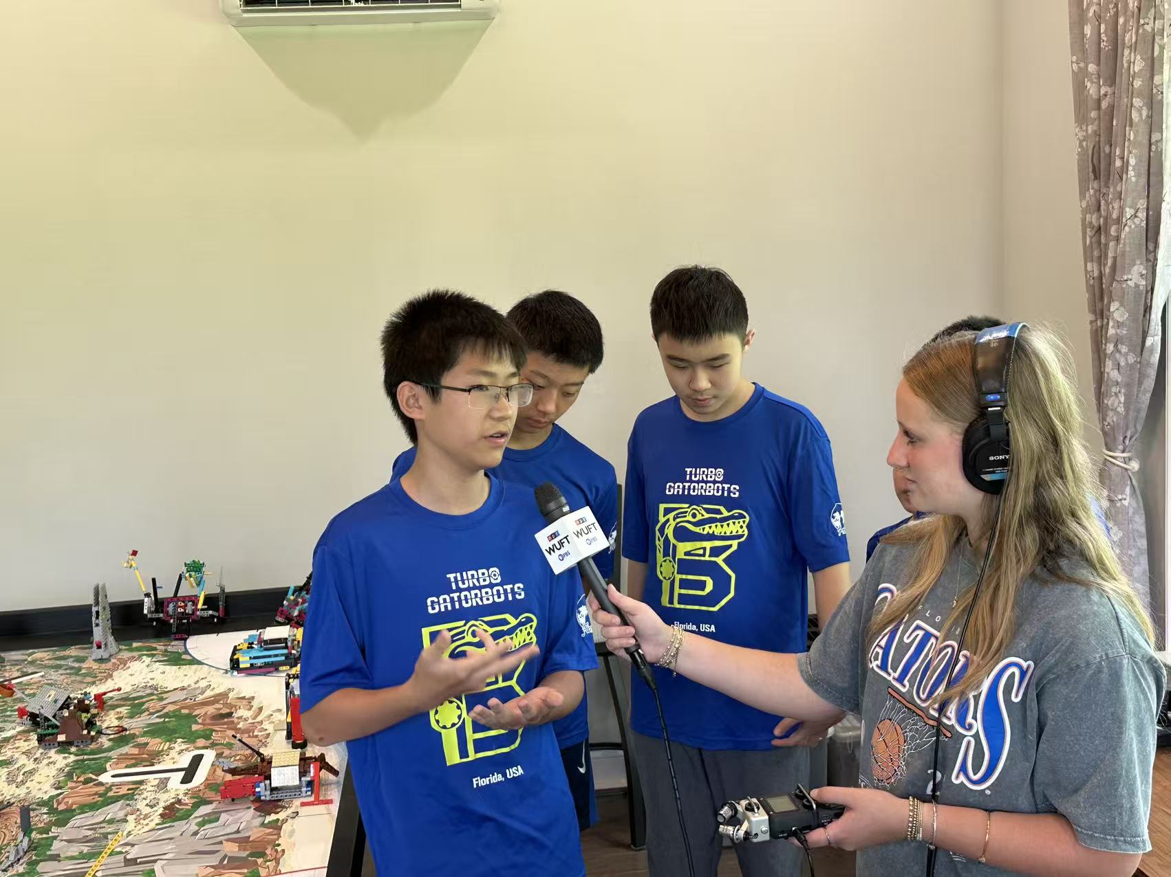 Turbo Gatorbots team members explaining their robot and mission strategy beside the FLL challenge table